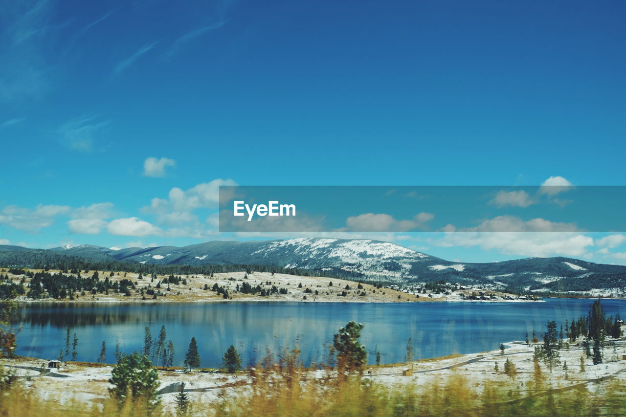 SCENIC VIEW OF LAKE BY MOUNTAIN AGAINST SKY