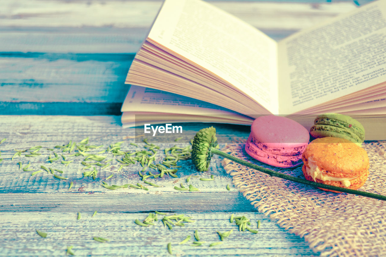 Macaroons with open book on table