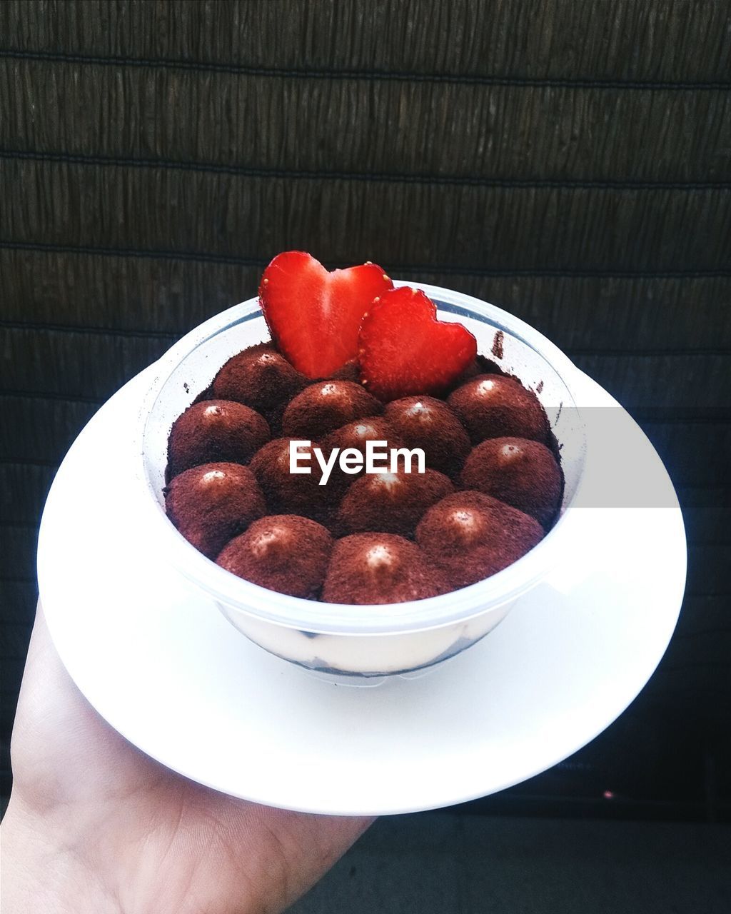 Close-up of hand holding dessert in bowl