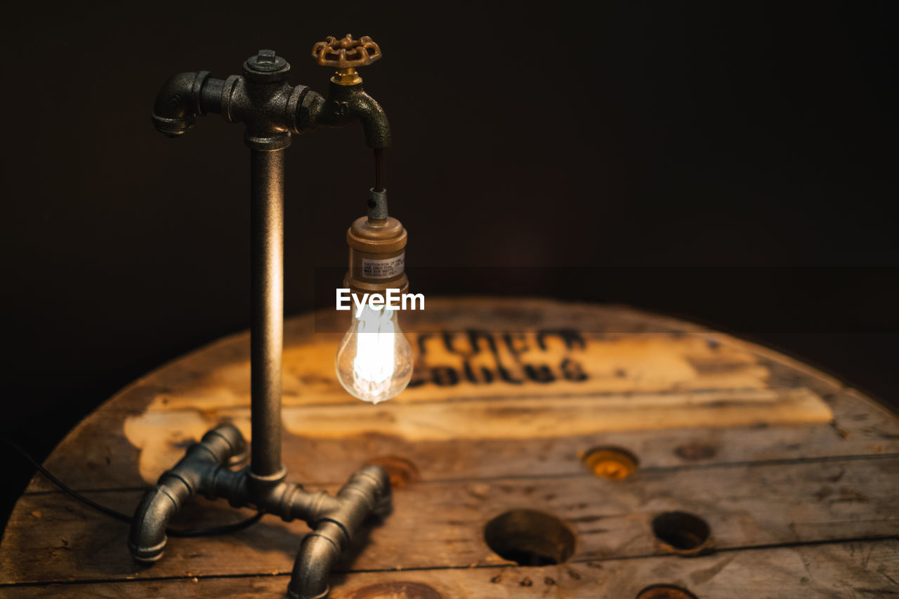 Close-up of illuminated electric bulb on tap