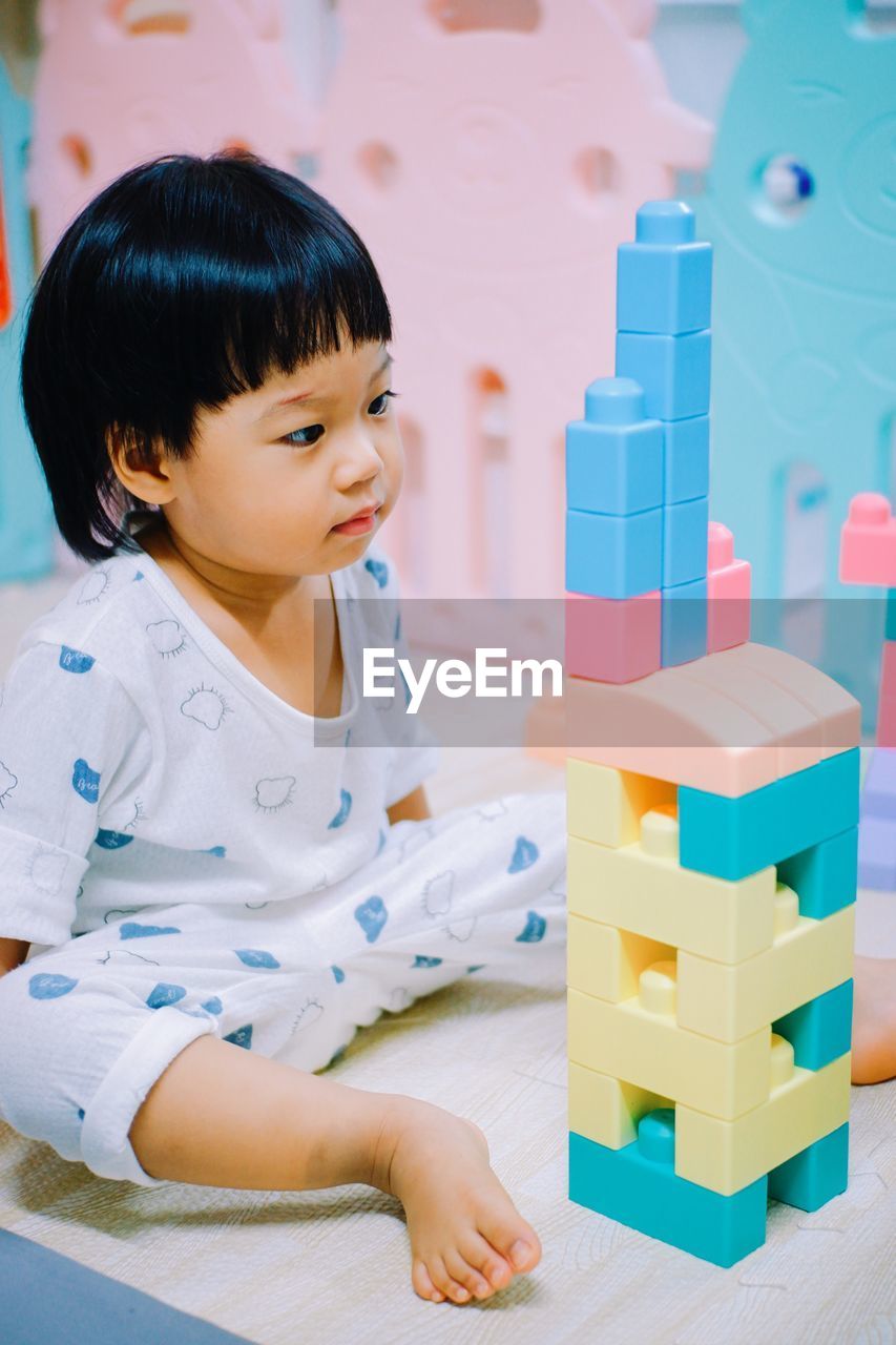 Cute girl playing with plastic toys