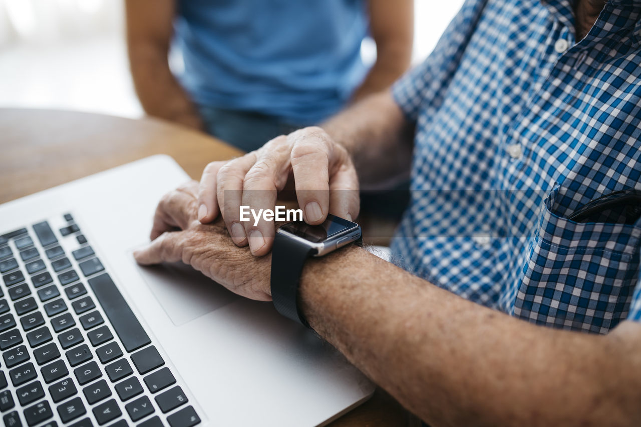 Senior man using smartwatch, close-up