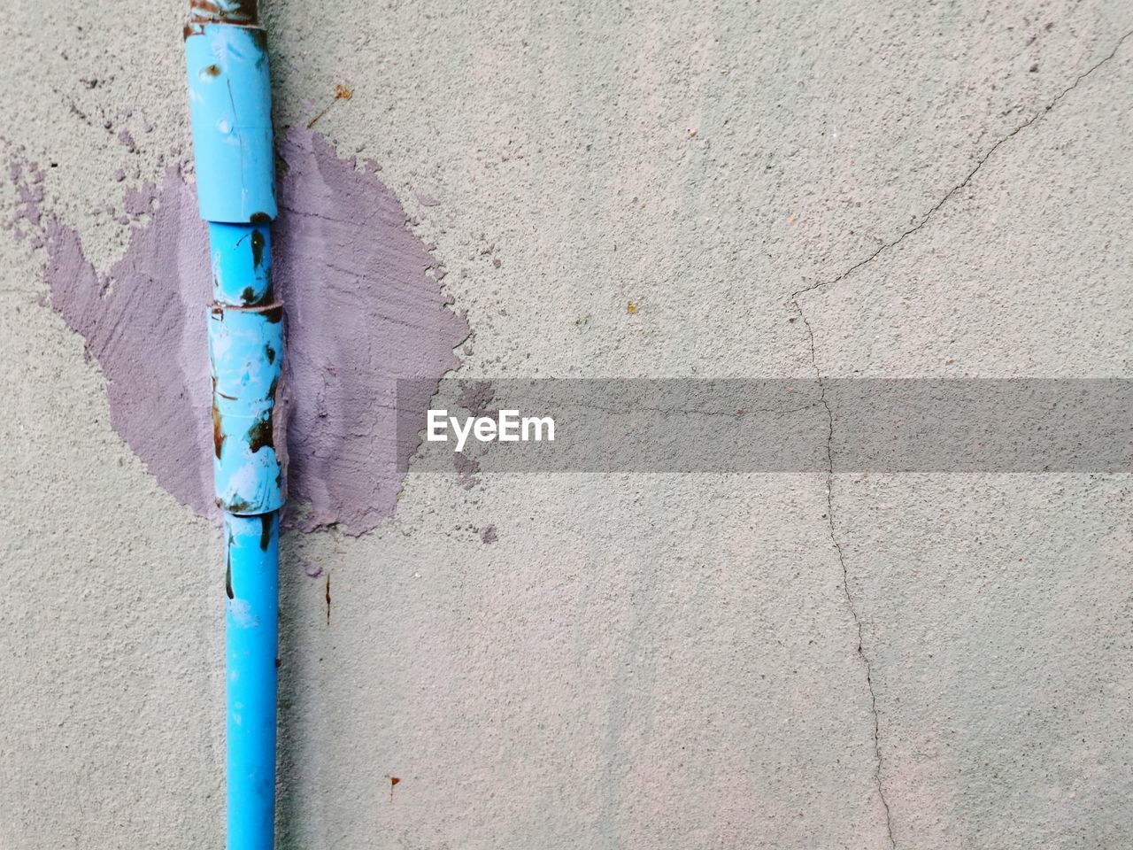 CLOSE-UP OF METAL PIPE ON WALL