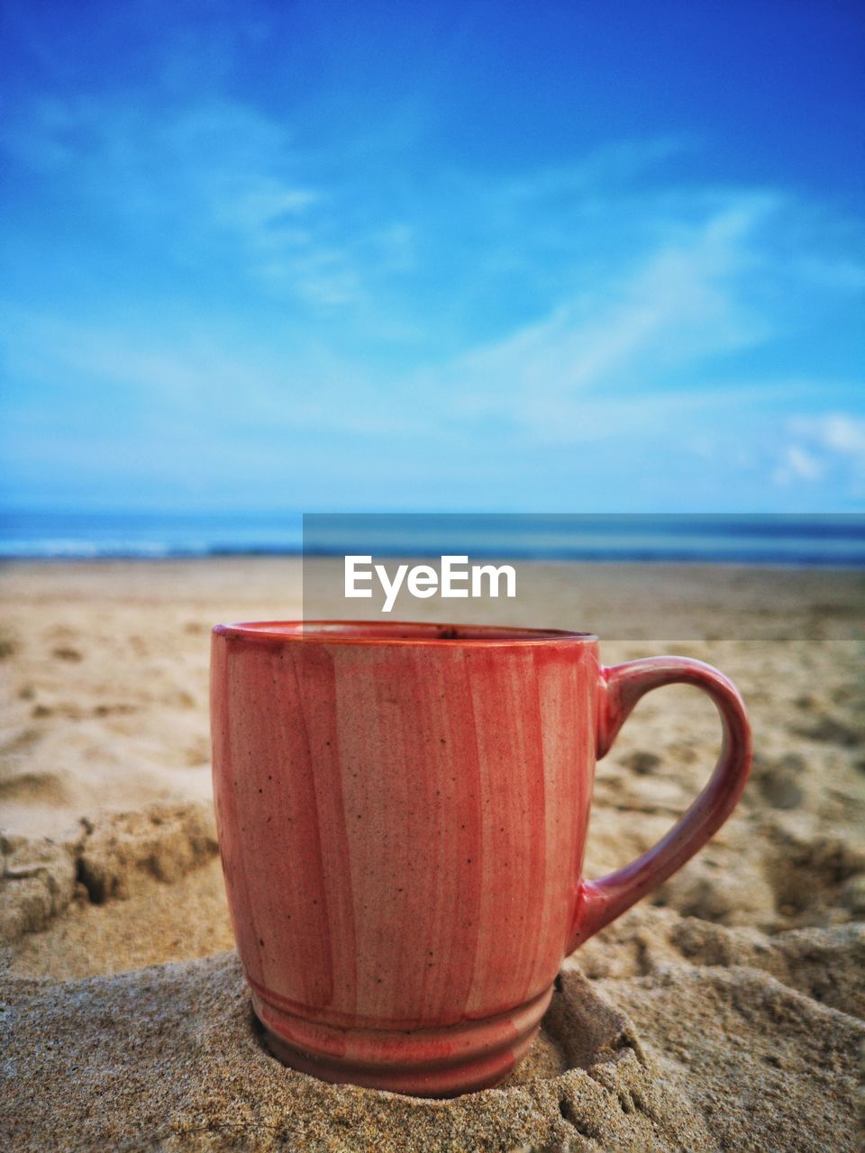 CLOSE-UP OF BEACH AGAINST BLUE SKY