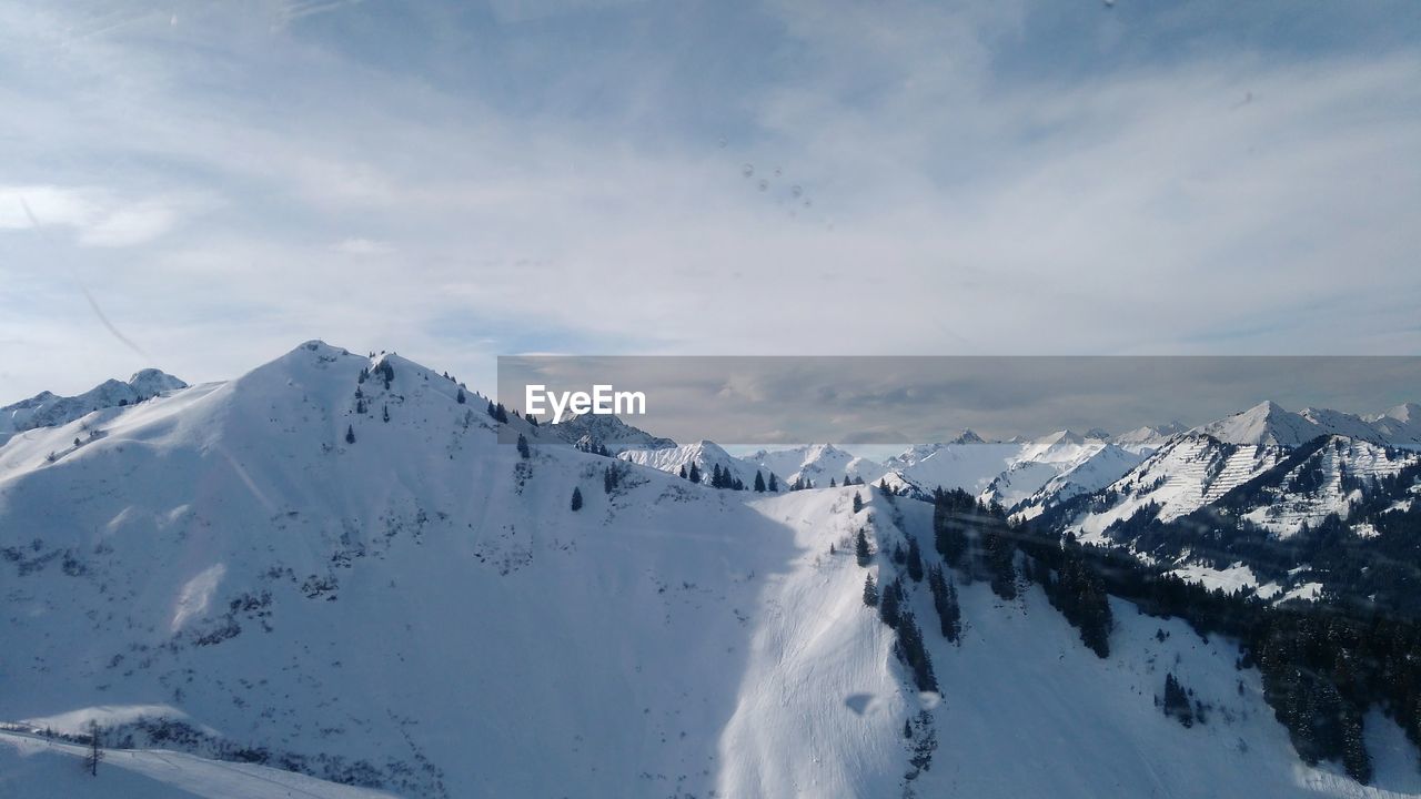 PANORAMIC VIEW OF SNOW COVERED MOUNTAINS AGAINST SKY