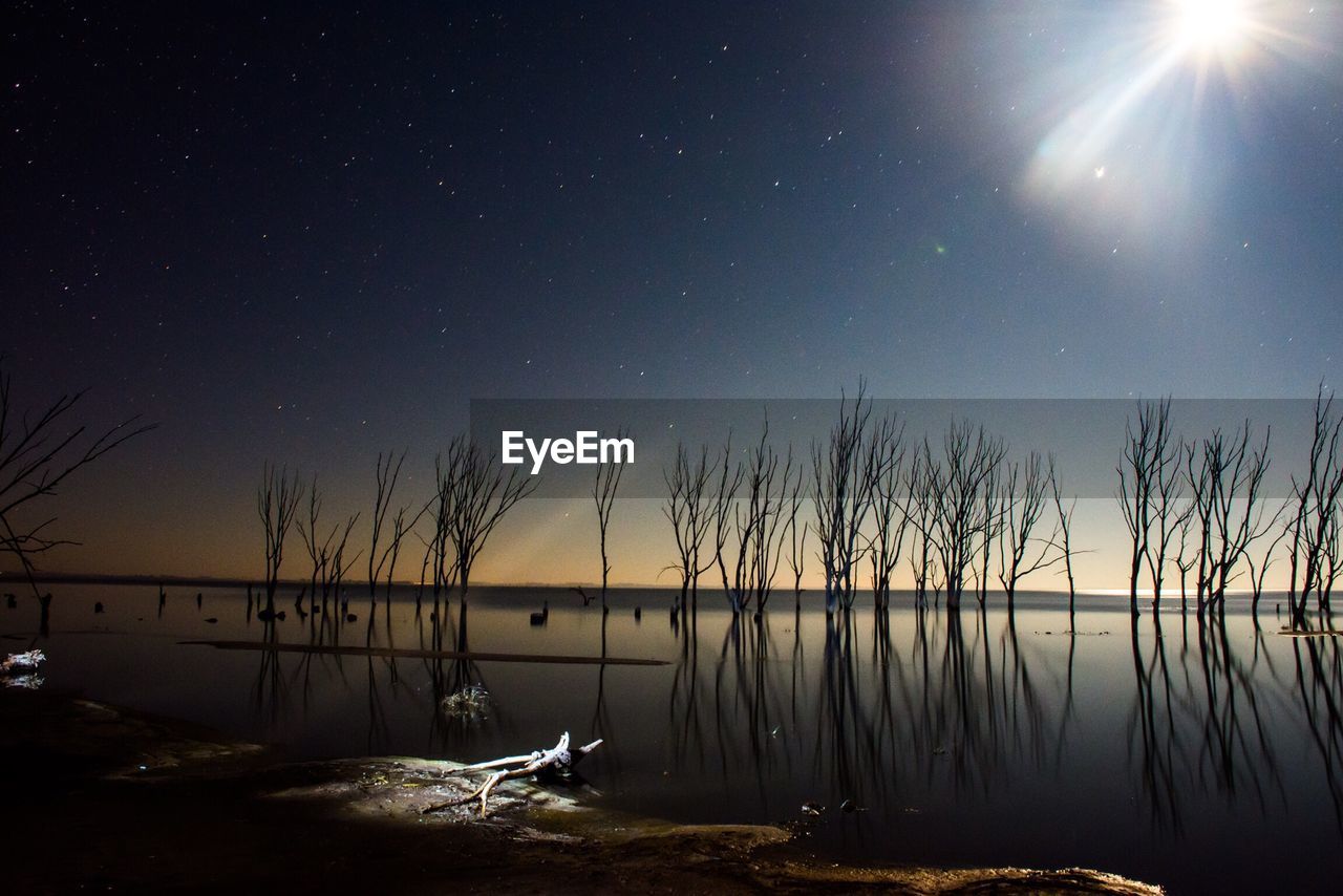 Scenic view of lake against sky at night