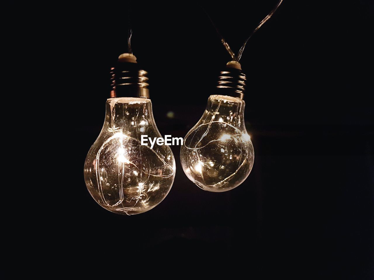 Close-up of illuminated light bulbs against black background