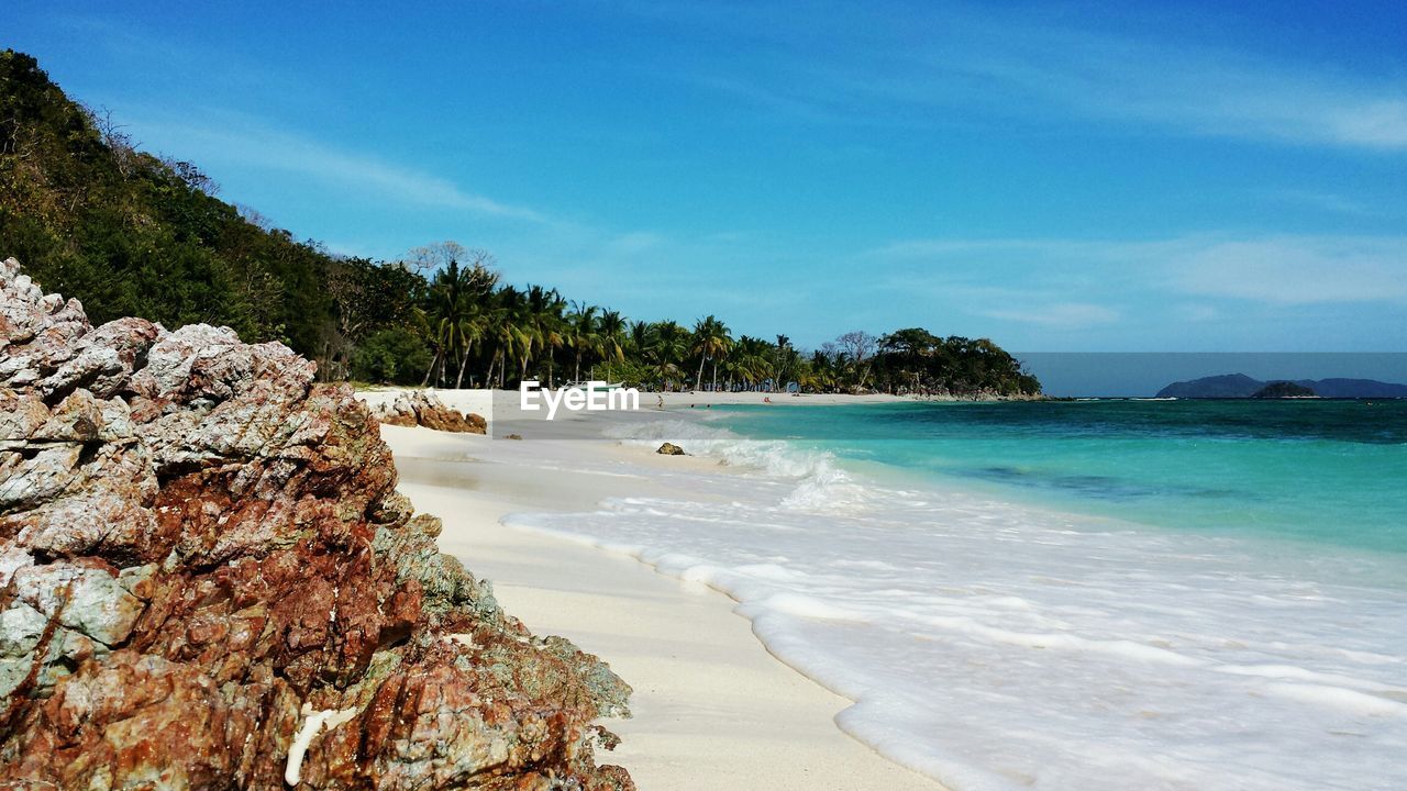 Scenic view of beach against blue sky