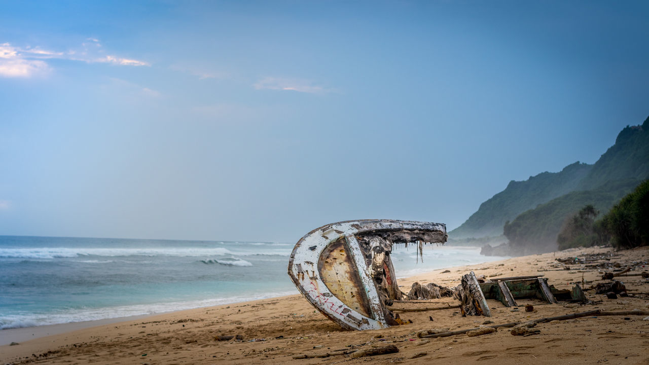Shipwreck on beach against sky