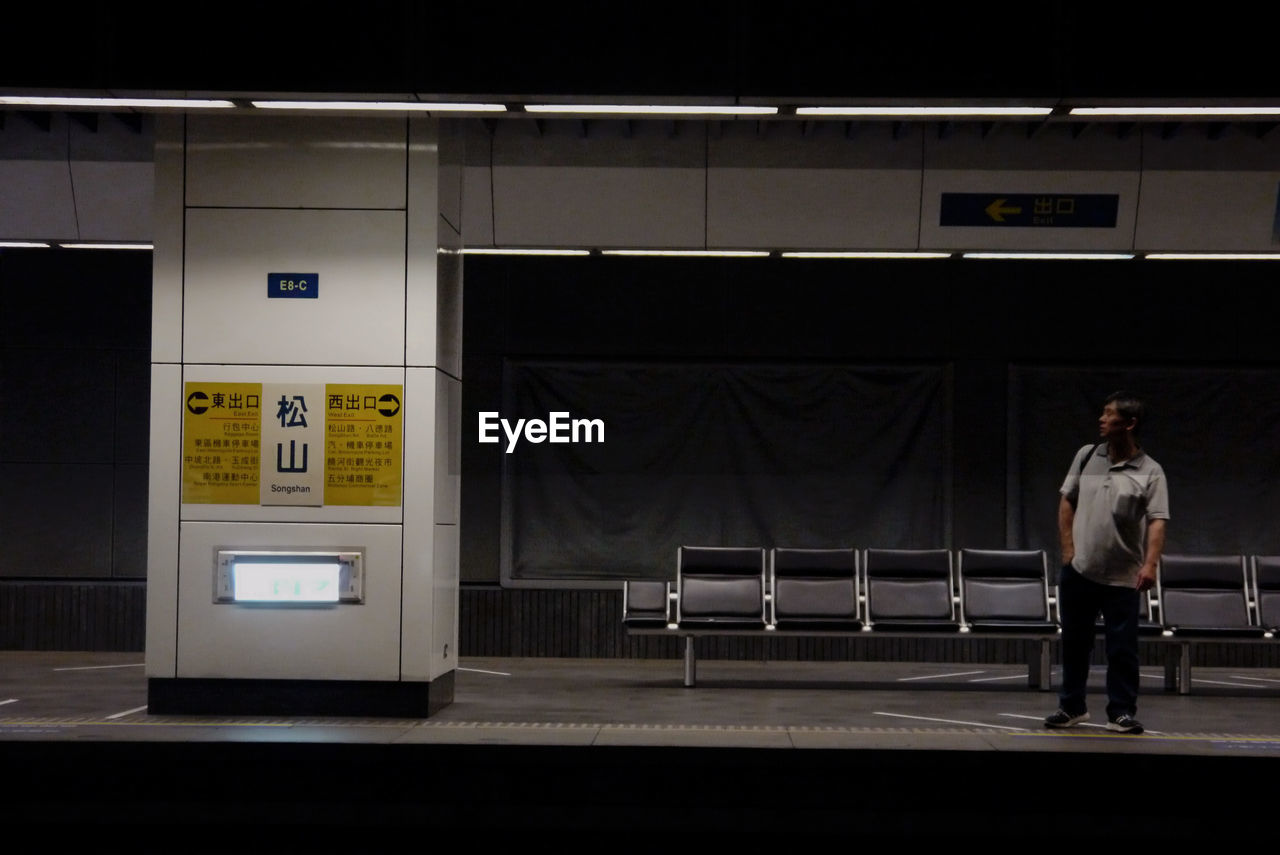 Full length of man standing at railroad station