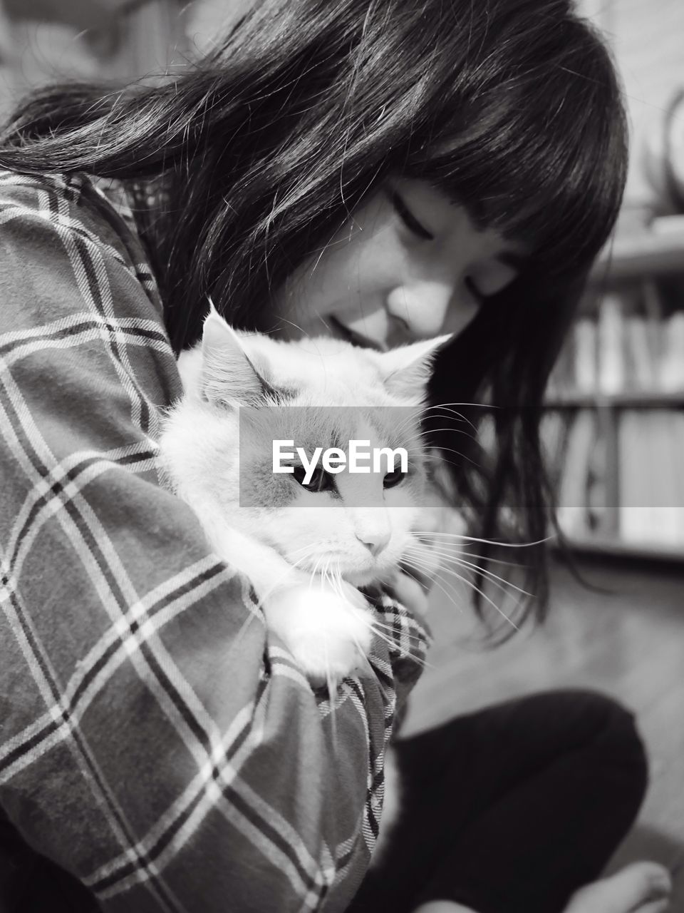 Close-up of teenage girl with cat sitting at home