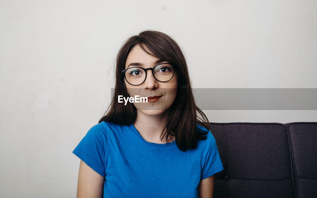 Portrait of beautiful young woman sitting at home