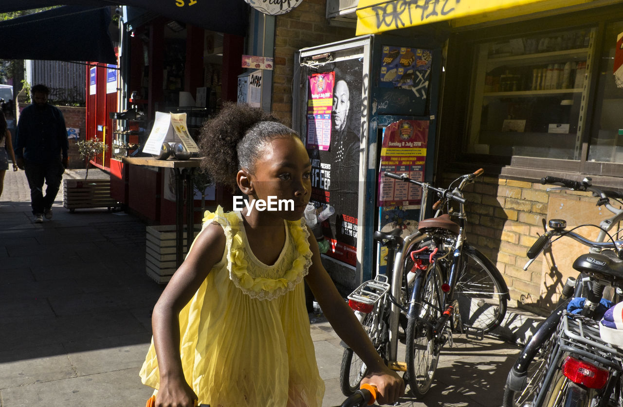 GIRL STANDING ON BICYCLE