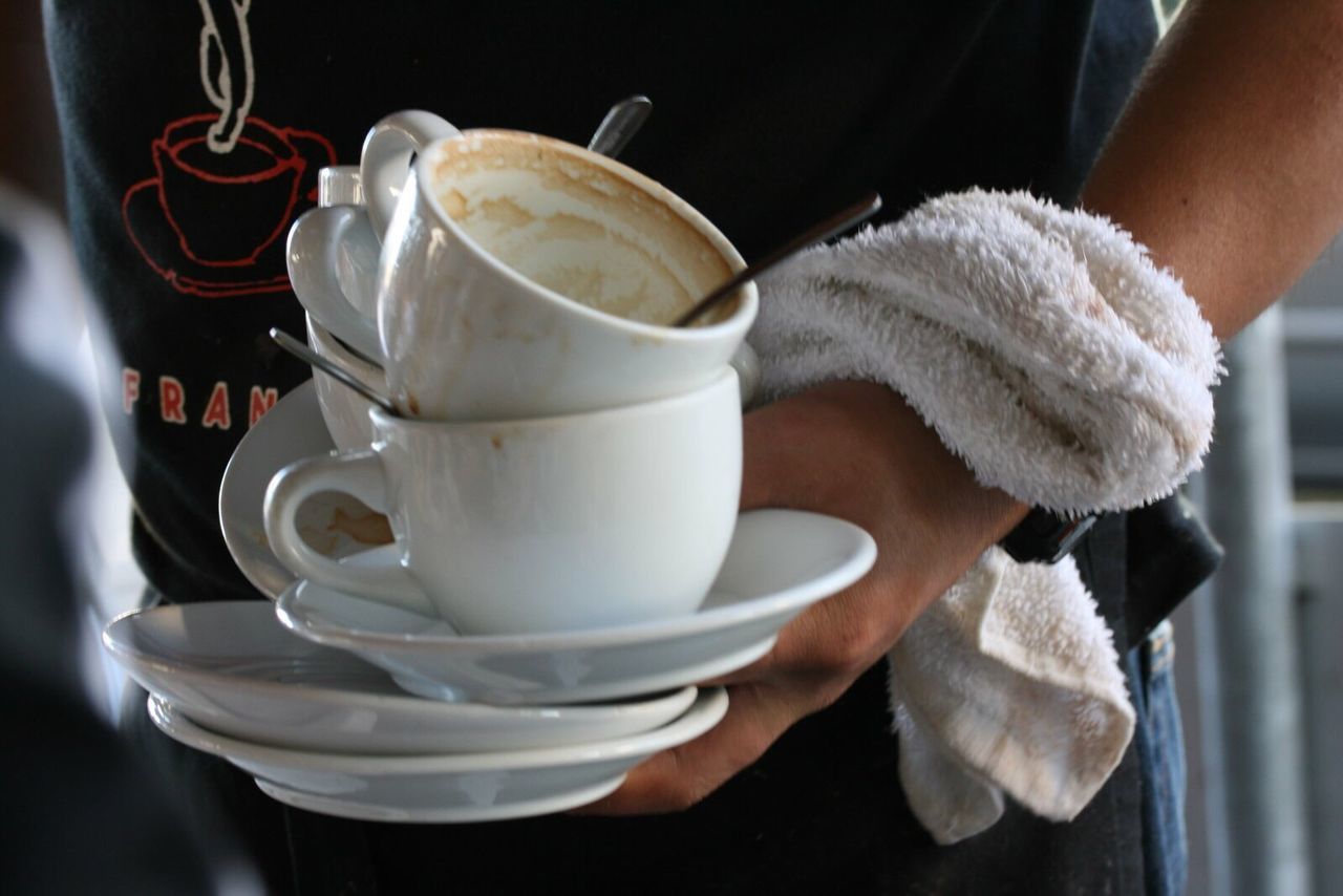 Man holding coffee cups at cafe