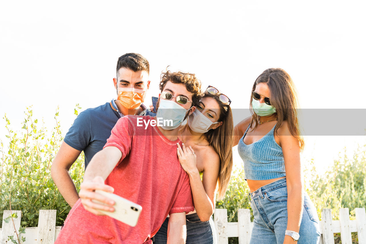 Friends taking selfie while standing outdoors