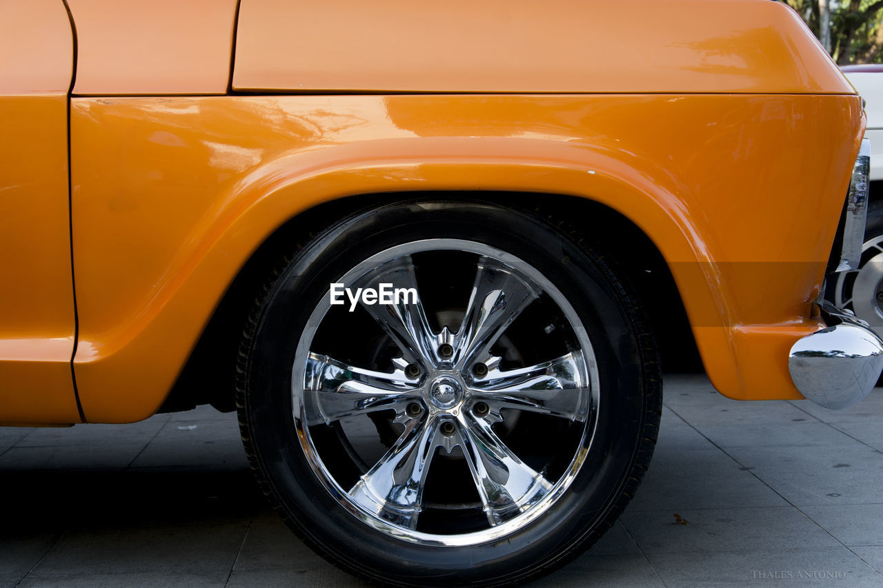 Detail of the wheel of an old car in a light orange color. salvador bahia brazil.