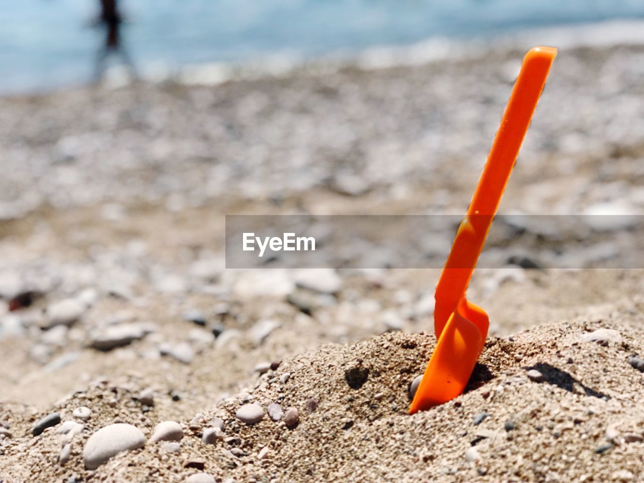 Close-up of orange toy on beach