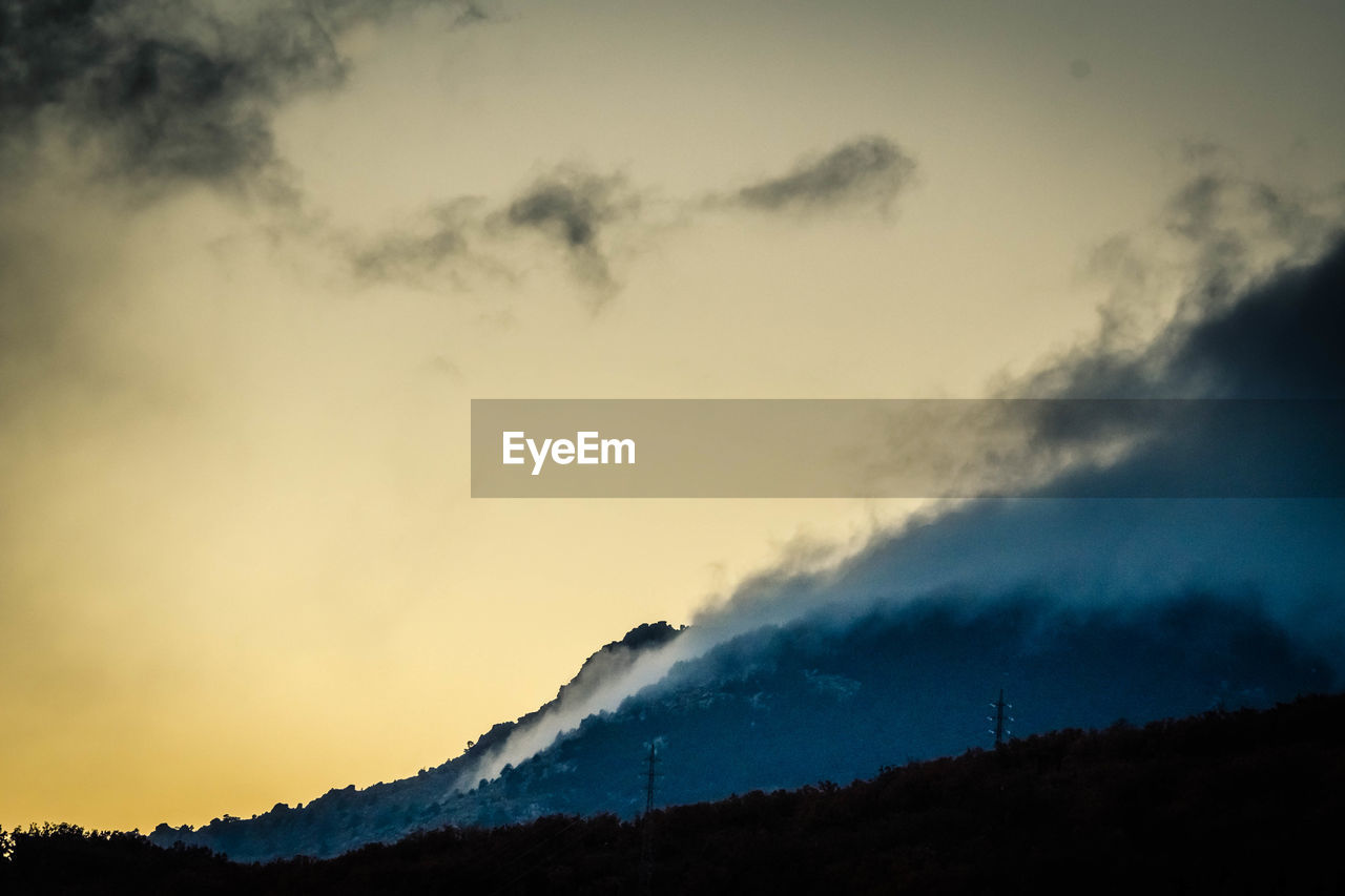 LOW ANGLE VIEW OF SILHOUETTE MOUNTAINS AGAINST SKY