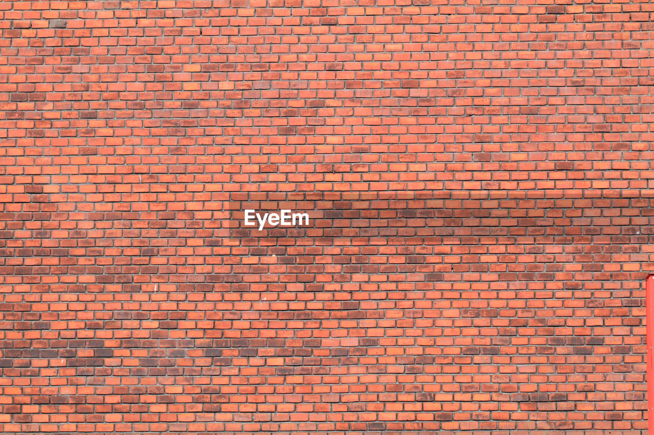 FULL FRAME SHOT OF BRICK WALL WITH RED ORANGE WALLS