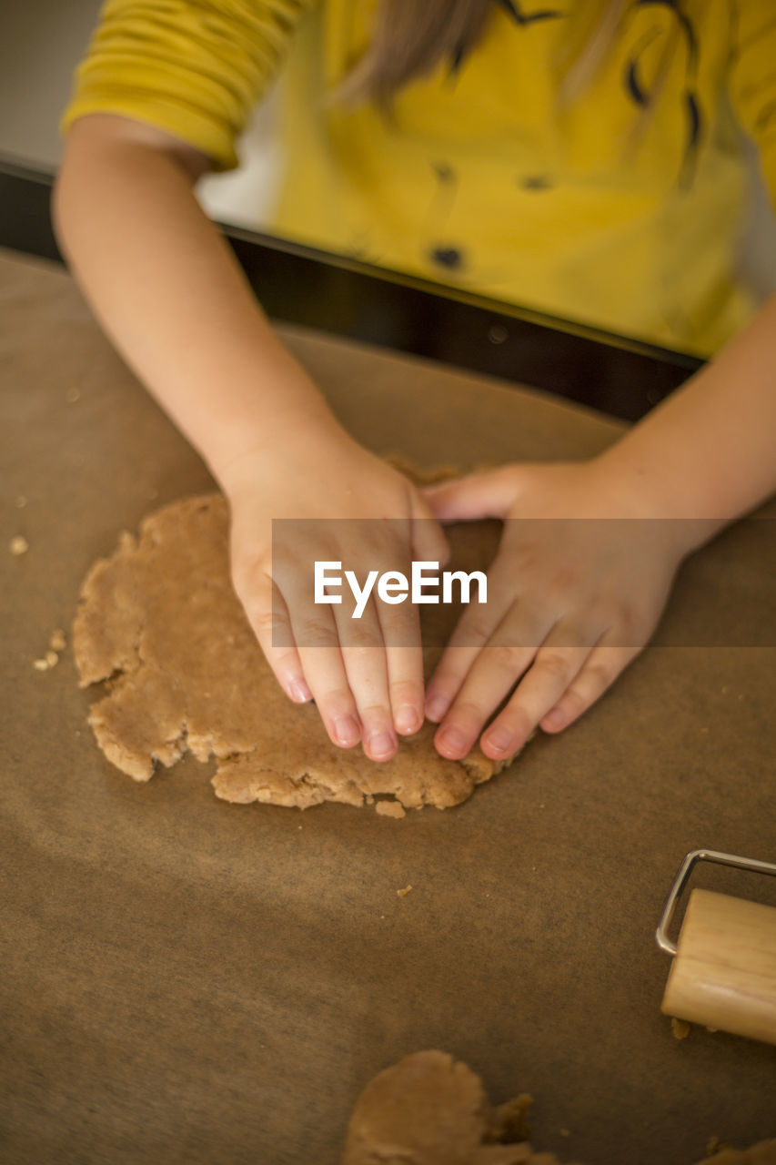 Midsection of girl preparing cookie at table