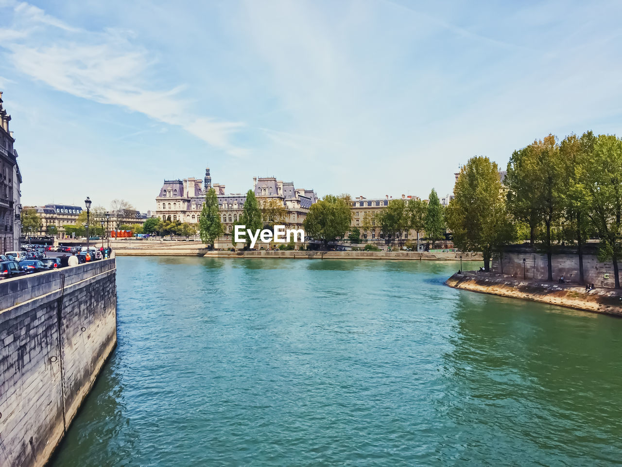 bridge over river by buildings against sky