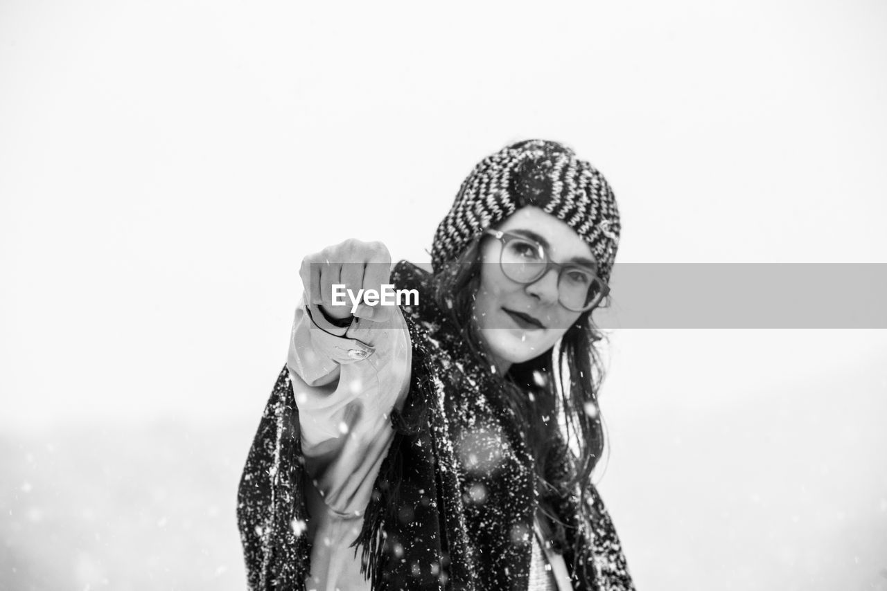 PORTRAIT OF A SMILING YOUNG WOMAN WITH SNOW