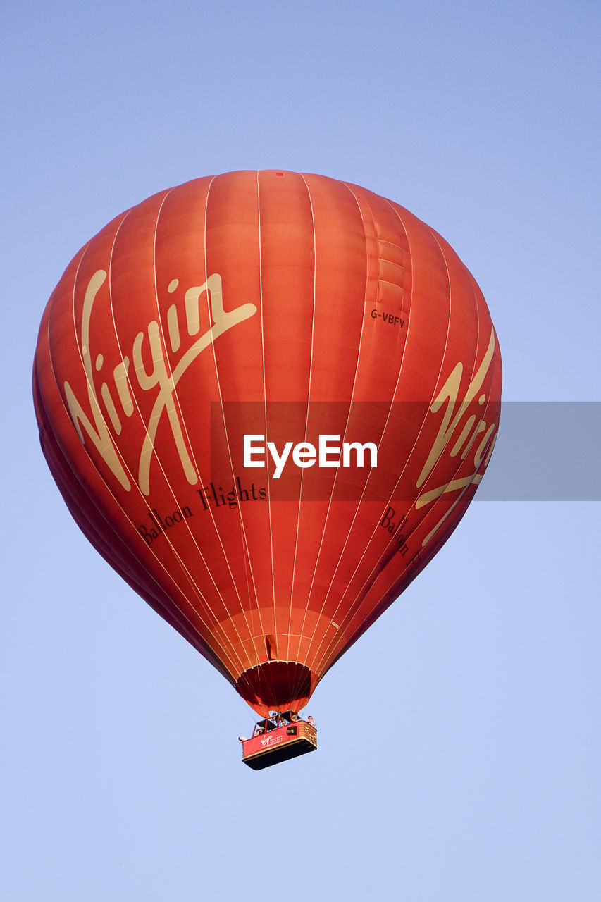 LOW ANGLE VIEW OF PERSON FLYING KITE AGAINST CLEAR SKY