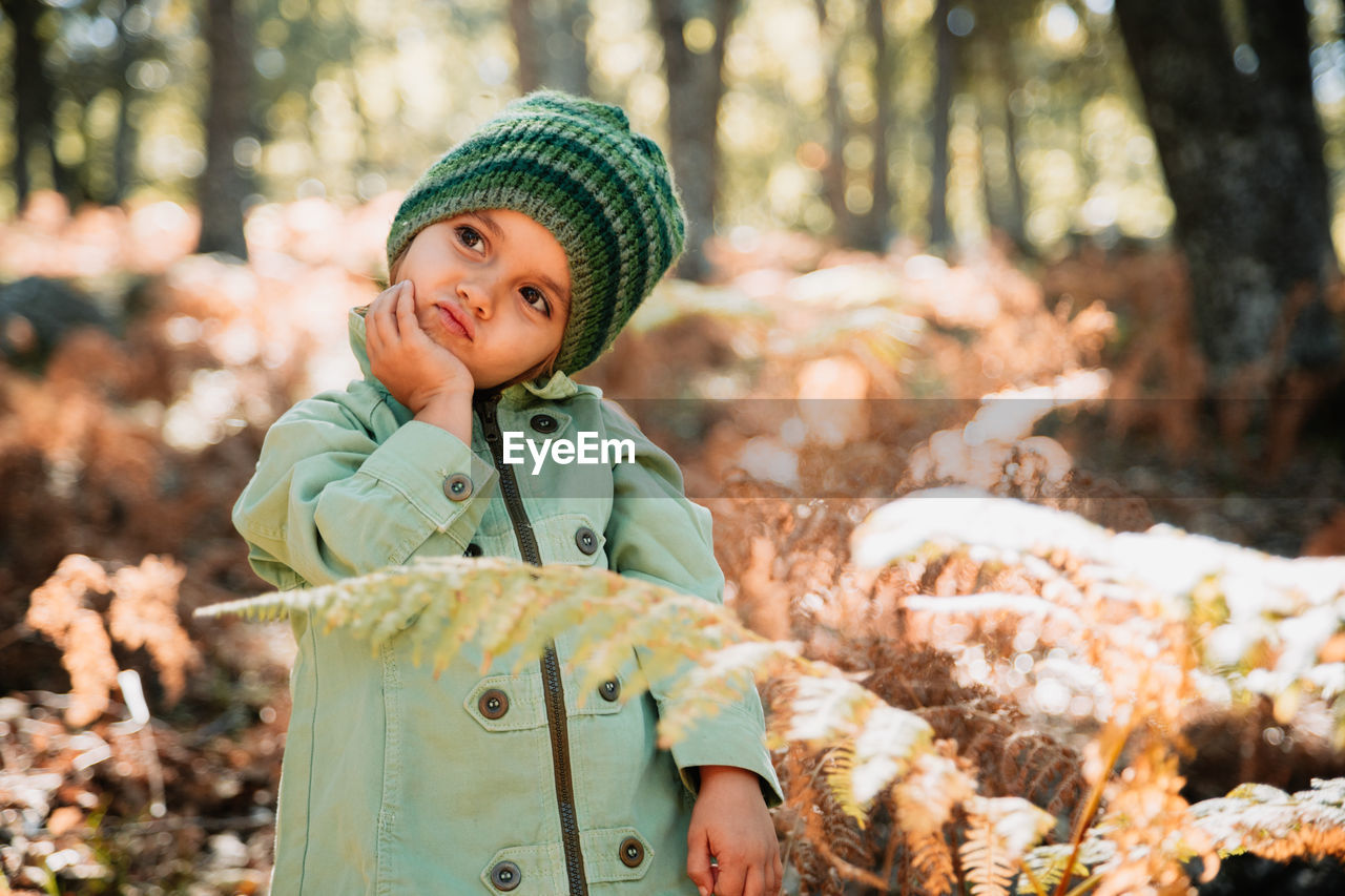 Close-up of girl standing amidst plants on field