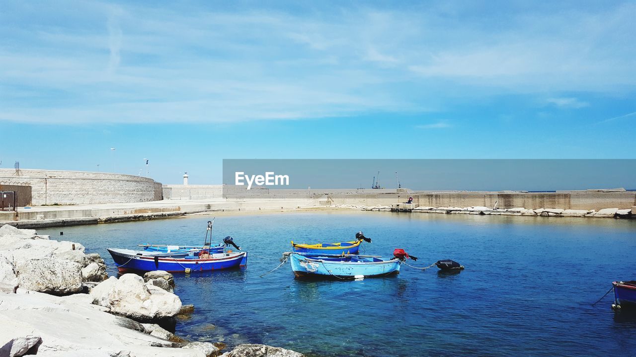 Boats moored on sea against blue sky