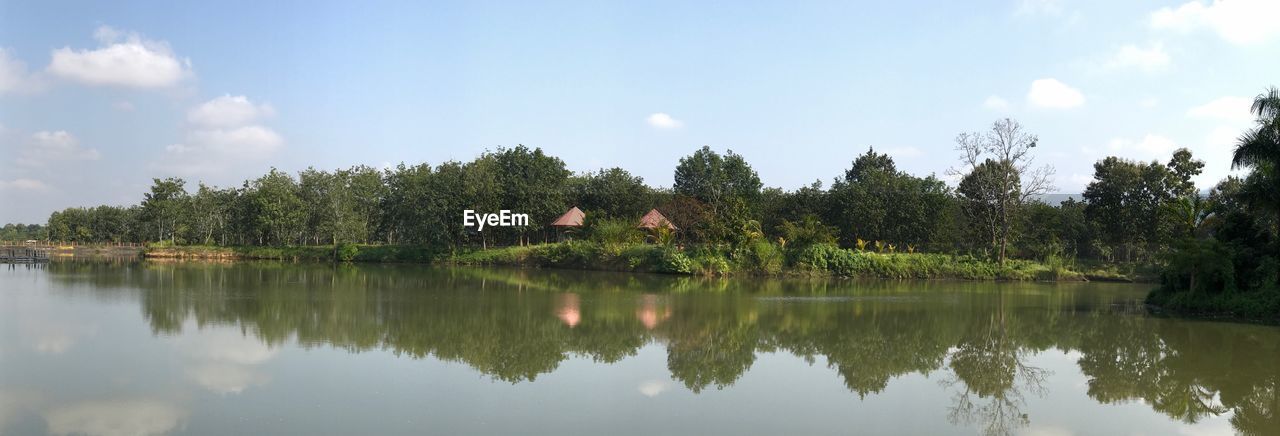 REFLECTION OF TREES IN LAKE AGAINST SKY