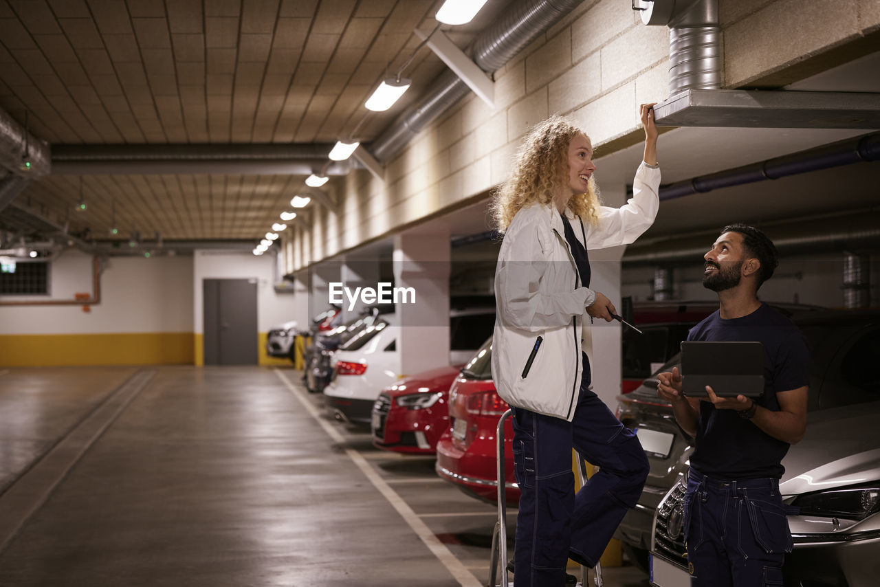 Man and woman checking air duct