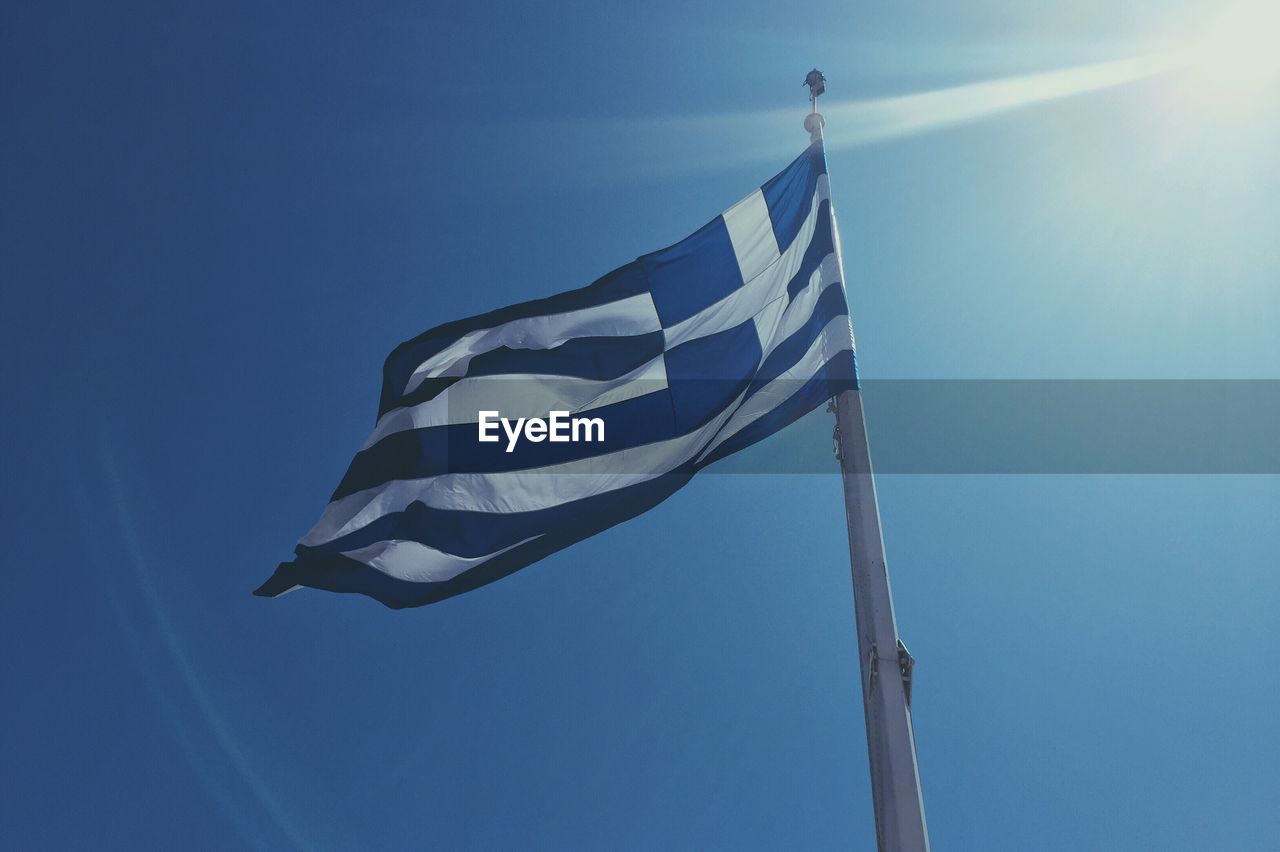 Low angle view of greek flag against sky