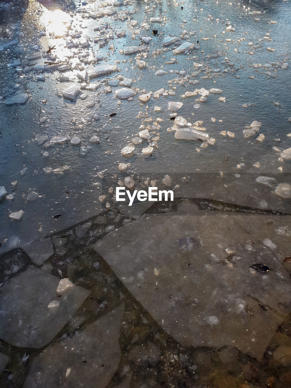 HIGH ANGLE VIEW OF PUDDLE IN LAKE DURING WINTER