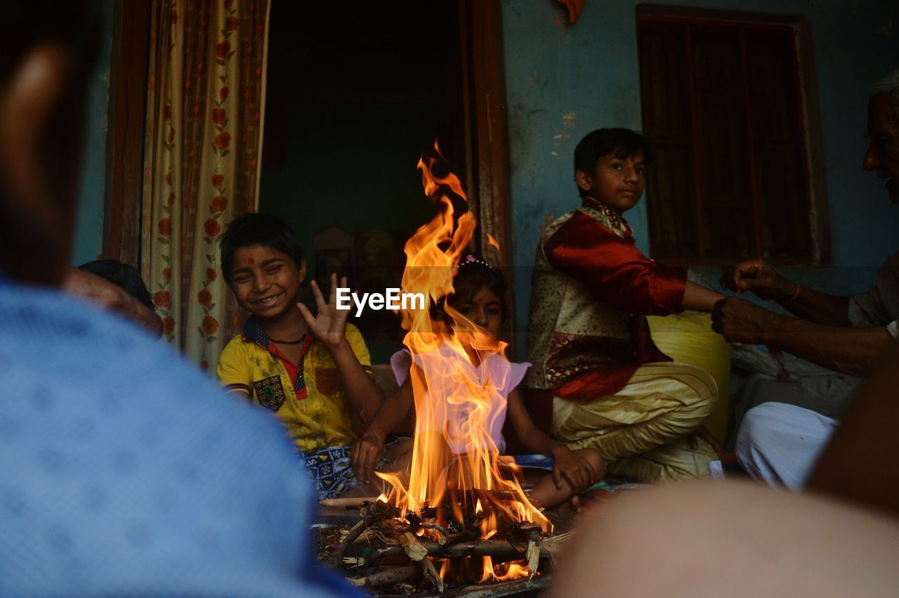 People sitting by fire at home