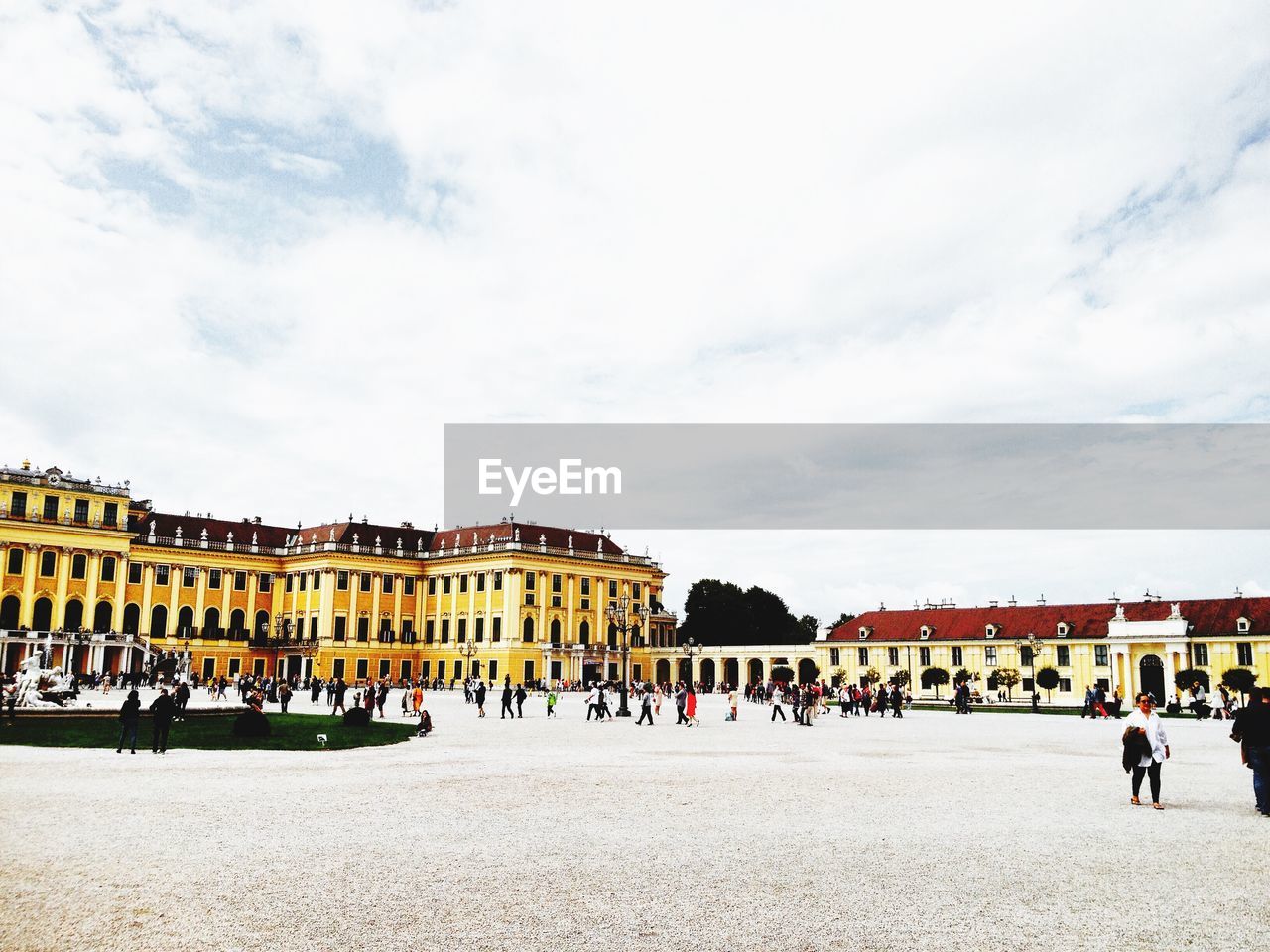 PEOPLE WALKING IN FRONT OF BUILDINGS AGAINST SKY