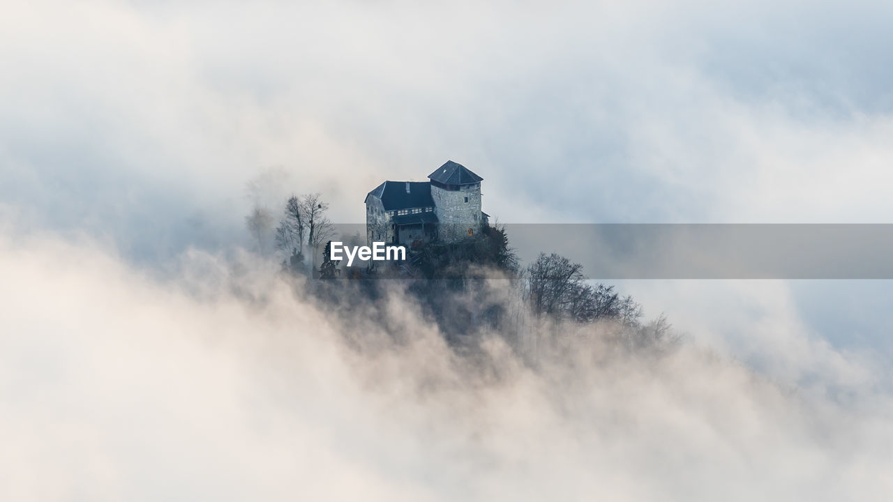 Scenic mystic view of a castle sourrounded by fog