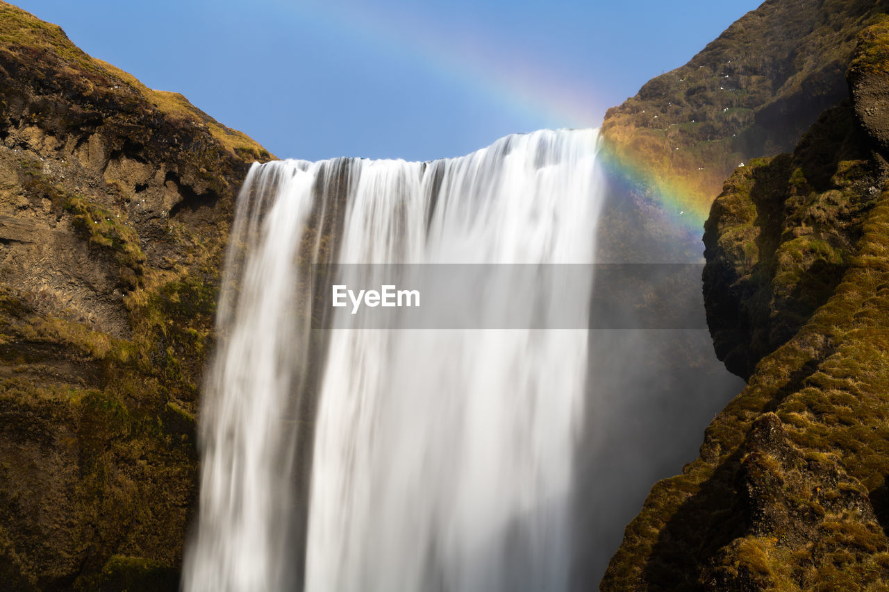 Scenic skogafoss waterfall with rainbow on a calm bright day in iceland