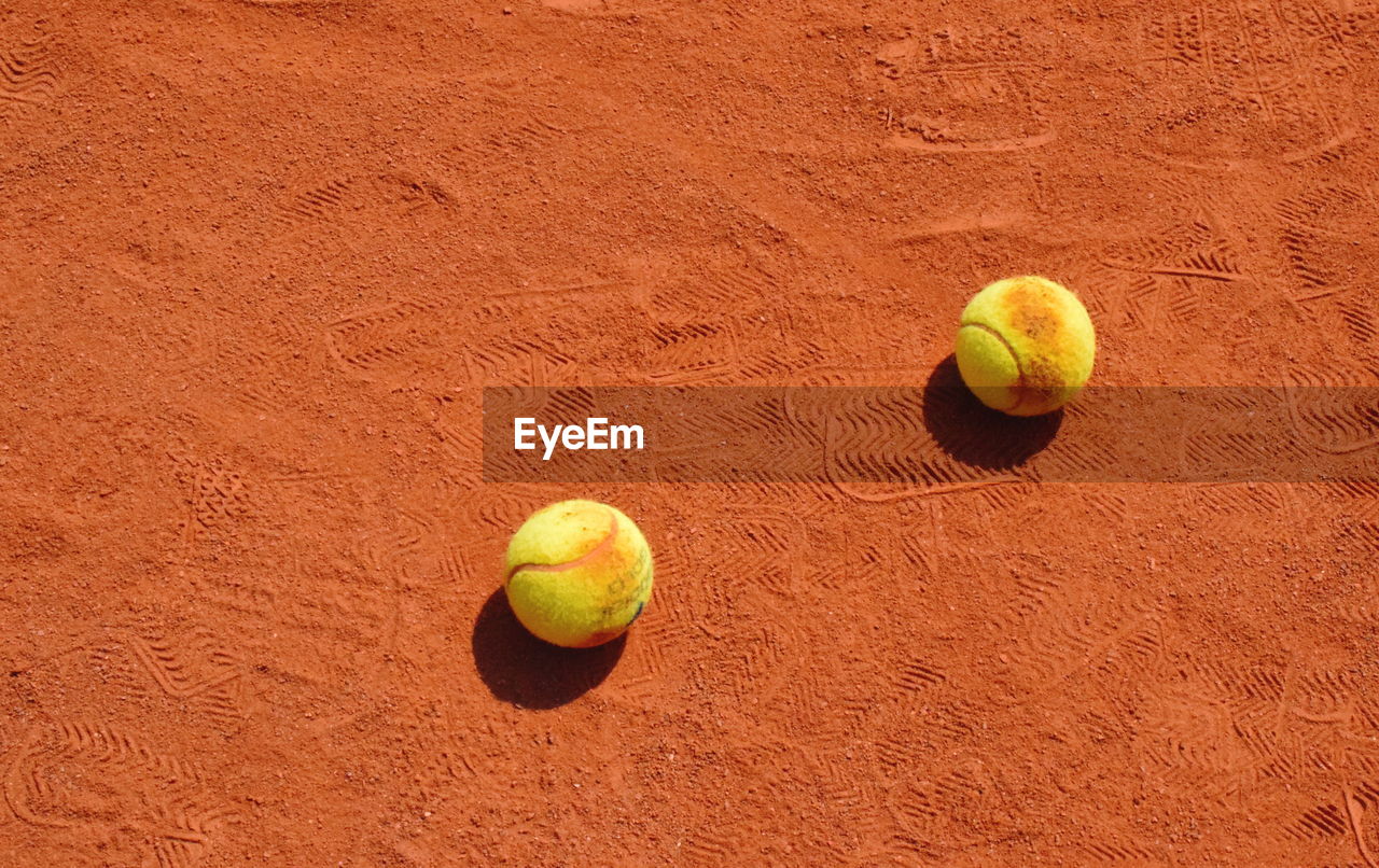 High angle view of tennis balls on sand