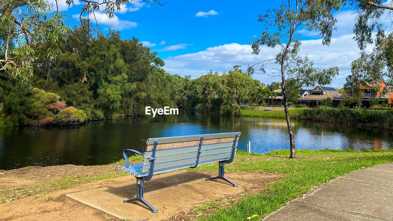 tree, plant, water, nature, lake, tranquility, beauty in nature, sky, seat, park, scenics - nature, tranquil scene, no people, bench, day, blue, sunlight, outdoors, cloud, relaxation, reflection, park - man made space, summer, green, travel destinations, body of water, idyllic, landscape, non-urban scene, beach, reservoir, estate, grass, environment, land, empty, chair, vacation, travel, trip