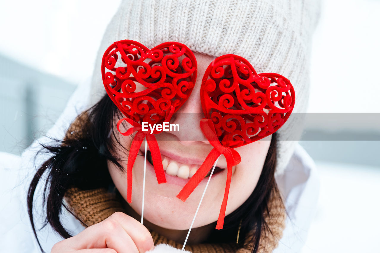 red, one person, women, heart shape, adult, emotion, positive emotion, valentine's day, love, clothing, flower, young adult, winter, celebration, lifestyles, romance, portrait, holding, female, front view, holiday, nature, close-up, happiness, white, indoors, event