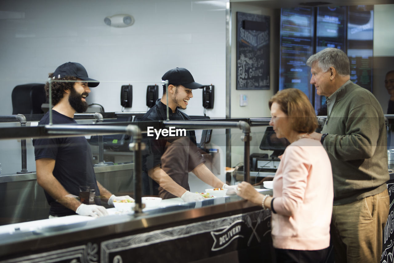 Senior couple ordering food at counter in restaurant