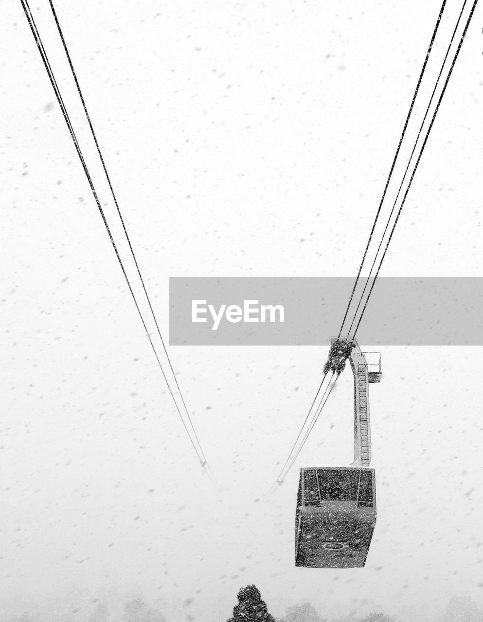 Low angle view of overhead cable car against clear sky during winter