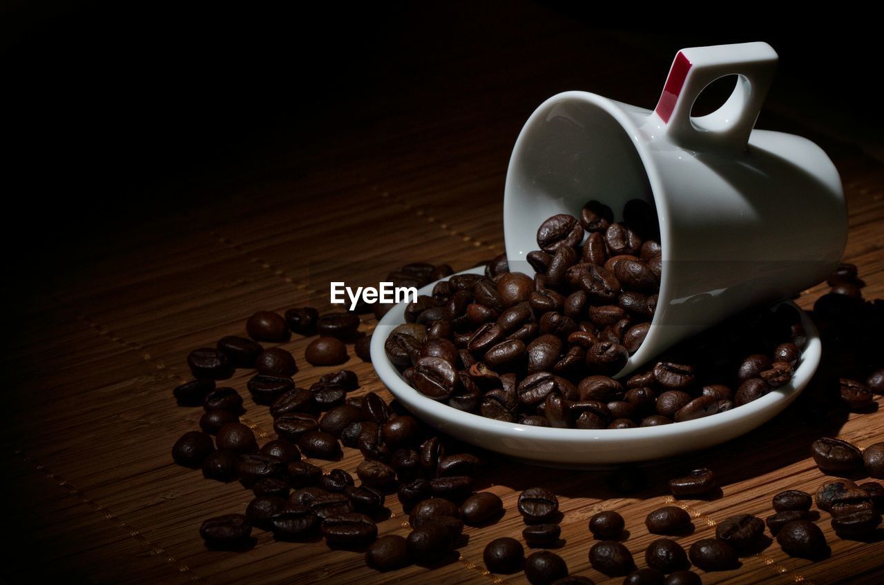 Coffee beans spilling out of cup