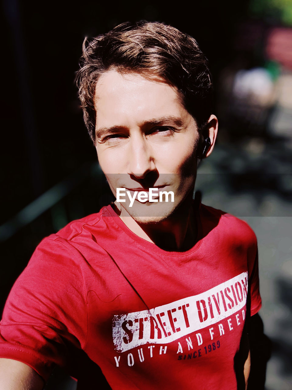 CLOSE-UP PORTRAIT OF A SERIOUS YOUNG MAN OUTDOORS