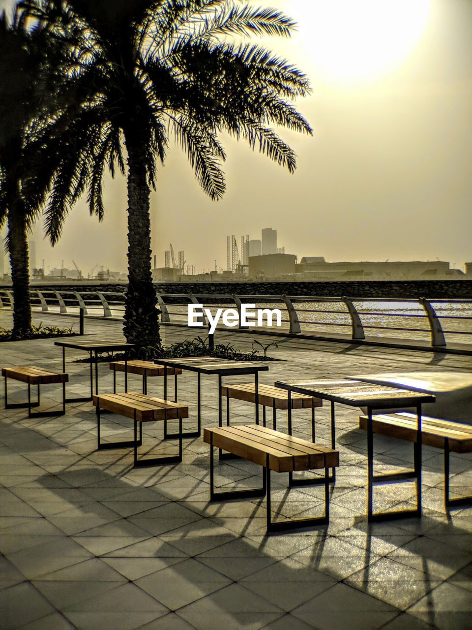 Empty chairs and table by sea against clear sky