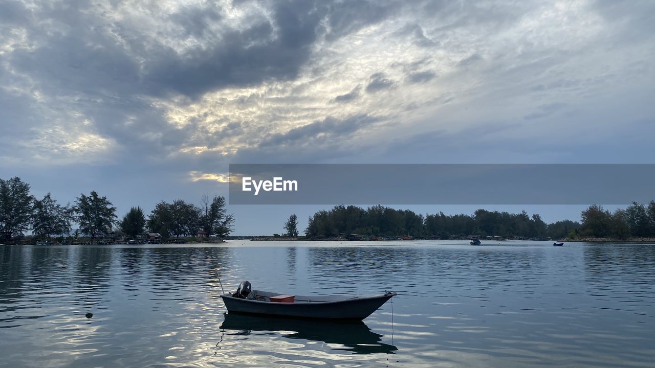 BOAT FLOATING ON WATER AGAINST SKY