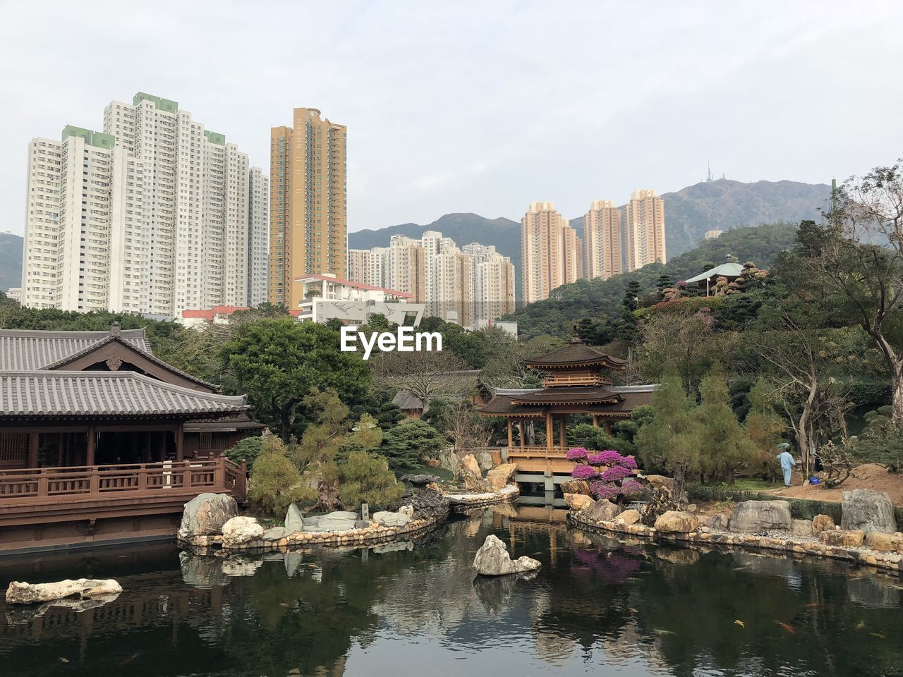 Buildings by river against sky in city