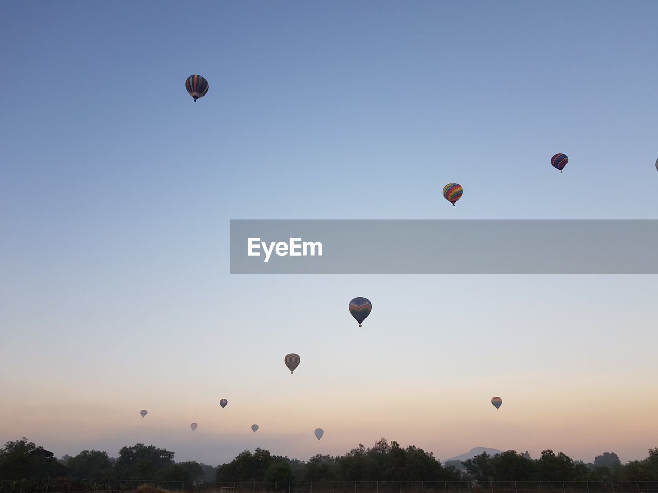 Low angle view of hot air balloons against sky during sunrise