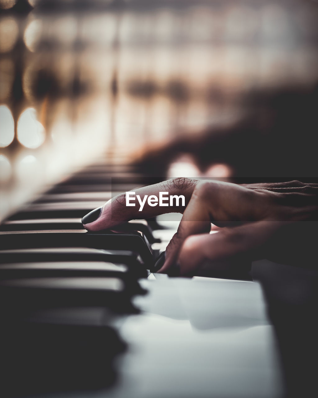 Cropped hand of woman playing piano