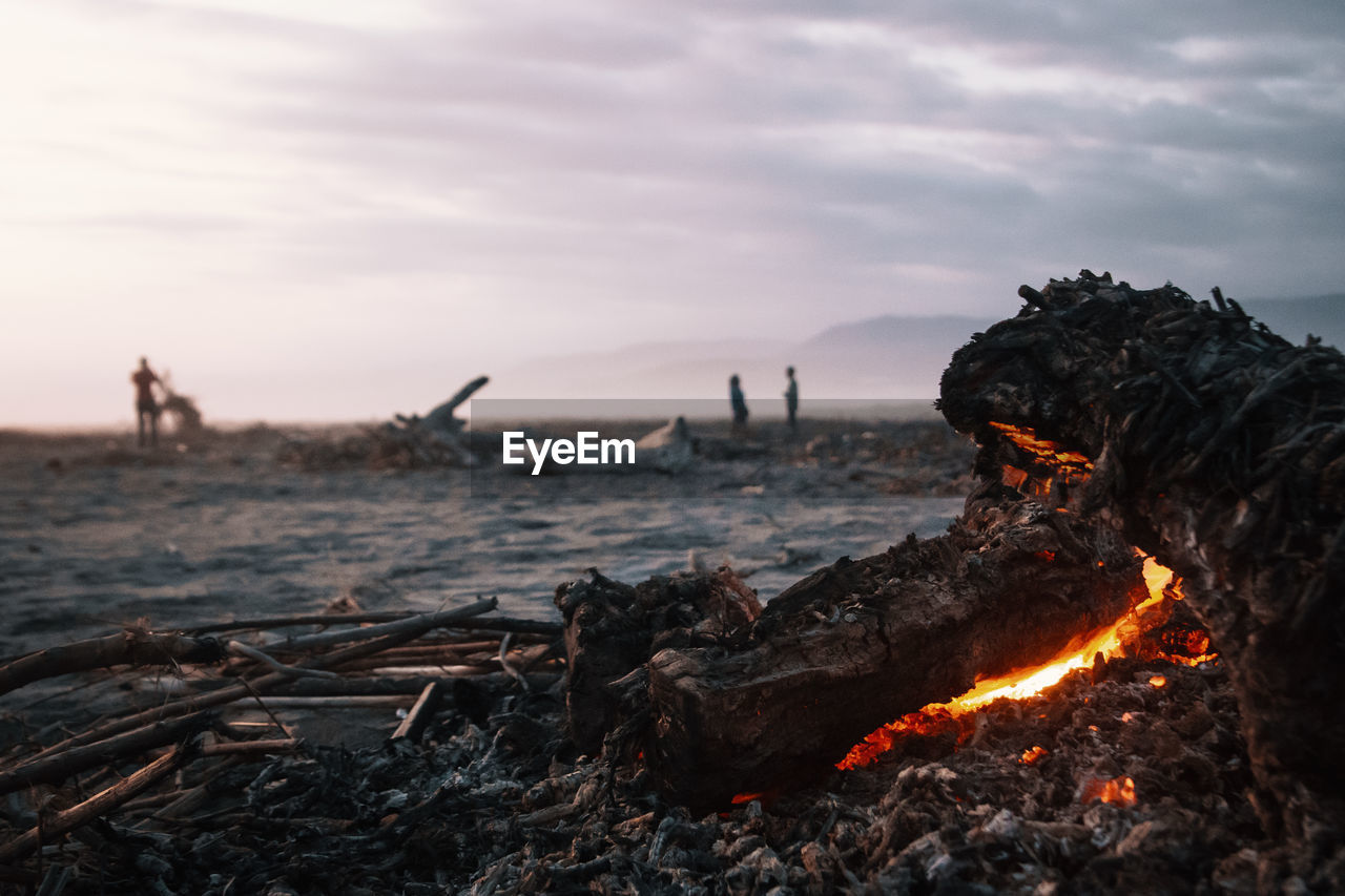 Close-up of bonfire against sky during sunset